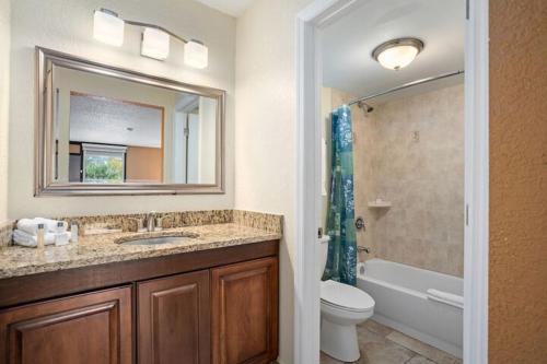 a bathroom with a sink and a toilet and a mirror at Royal 1 in Kissimmee