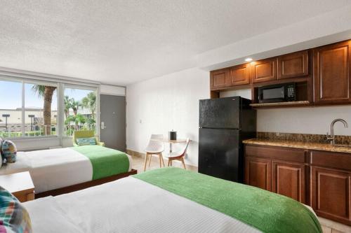 a hotel room with two beds and a kitchen at Royal 1 in Kissimmee