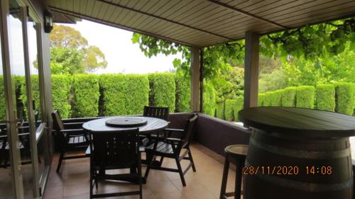 a patio with tables and chairs on a porch at Bush Line Lodge in Motueka