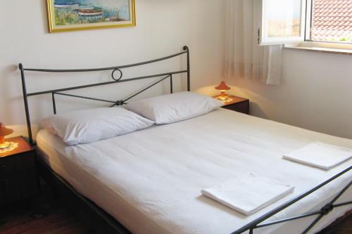 um quarto com uma cama branca com duas toalhas em Apartment Pisak 967b em Mimice