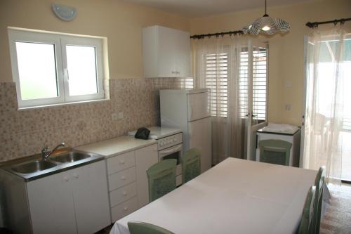 a kitchen with a sink and a white refrigerator at Apartment Seget Vranjica 1051b in Seget Vranjica