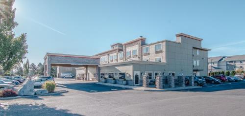 a building with cars parked in a parking lot at Best Western PLUS Peppertree Airport Inn in Spokane