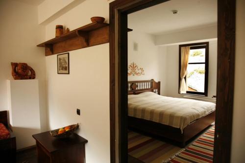 a bedroom with a bed and a mirror at Family Hotel Arkan Han in Trigrad