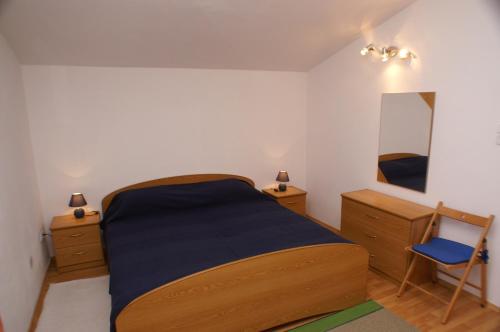 ein Schlafzimmer mit einem Bett, zwei Kommoden und einem Spiegel in der Unterkunft Apartment Tisno 814b in Tisno