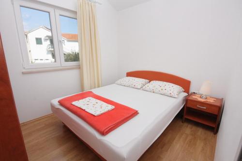 a small bedroom with a bed and a window at Apartments by the sea Postira, Brac - 705 in Postira