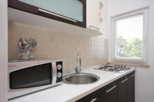 a kitchen with a sink and a microwave at Apartments by the sea Postira, Brac - 705 in Postira