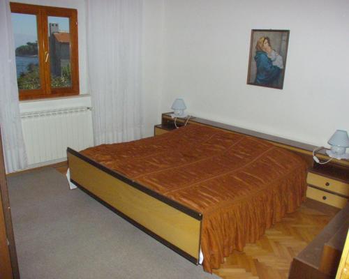 a bedroom with a bed with a orange bedspread at Apartments by the sea Postira, Brac - 738 in Postira