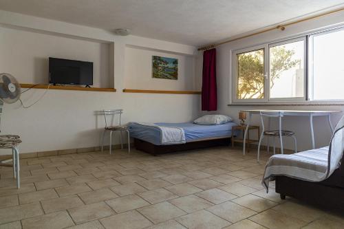 a bedroom with a bed and a tv on the wall at Apartments by the sea Maslinica, Solta - 775 in Grohote