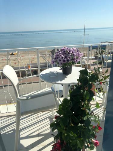 einen Tisch und Stühle auf einem Balkon mit Strandblick in der Unterkunft B&B El Gatt in Marotta