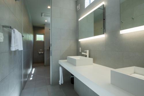 a bathroom with two sinks and a mirror at Annupuri Onsen Chalet in Niseko