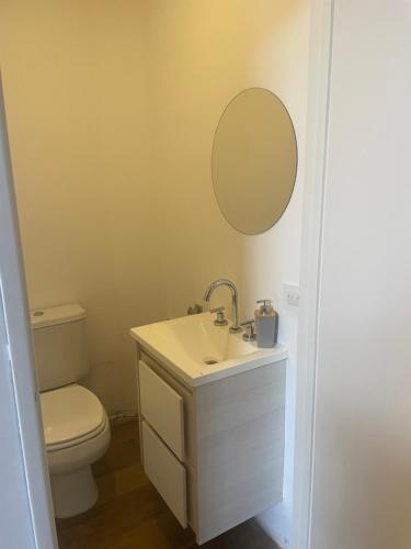 a bathroom with a toilet and a sink and a mirror at LOFT centrico 11 de Abril in Bahía Blanca