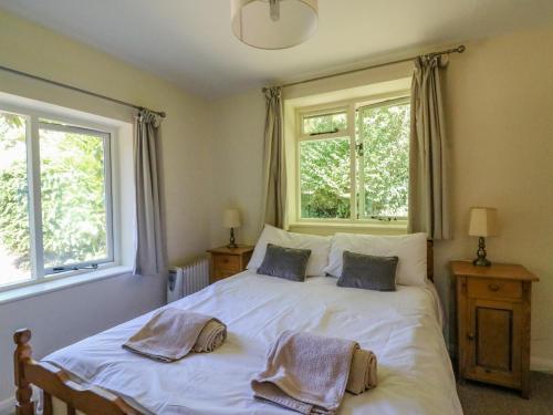 um quarto com uma cama com duas toalhas em Fossil And The Cross Cottage em Swyre