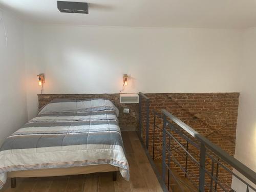 una cama en una habitación con una pared de ladrillo en LOFT centrico 11 de Abril, en Bahía Blanca