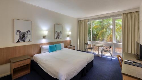 Habitación de hotel con cama, mesa y ventana en Swan Hill Resort en Swan Hill