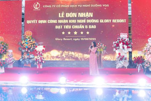 河内Glory Resort的一名女子站在舞台上，面前是一块屏幕。