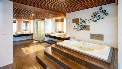 a large bathroom with a tub and two sinks at Khum Phucome Hotel -SHA Extra Plus in Chiang Mai