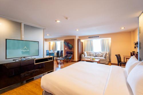a hotel room with a bed and a flat screen tv at Khum Phucome Hotel -SHA Extra Plus in Chiang Mai