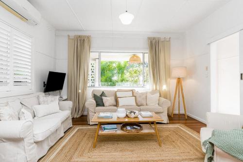 a living room with a white couch and a table at Bungalow105 in Byron Bay