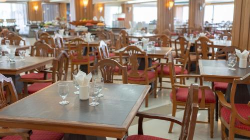 a restaurant with tables and chairs with glasses on them at Khum Phucome Hotel -SHA Extra Plus in Chiang Mai