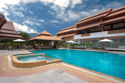 a large swimming pool in front of a building at Khum Phucome Hotel -SHA Extra Plus in Chiang Mai