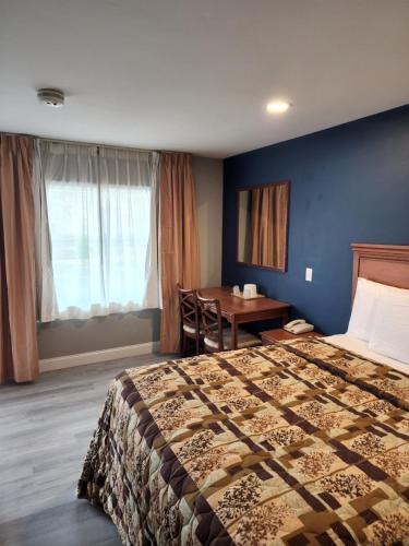 a hotel room with a bed and a desk at Budget Inn Horseheads in Horseheads