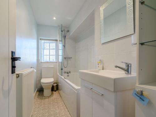 a white bathroom with a sink and a toilet at Corner Cottage in York