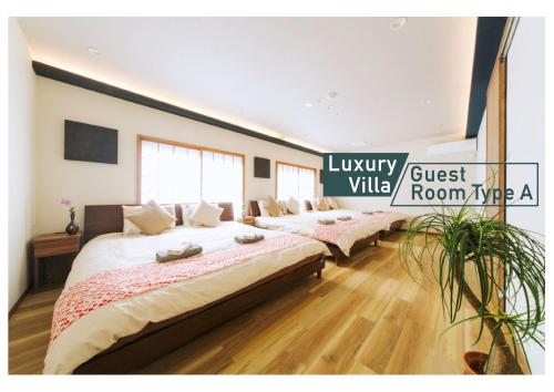 a room with four beds in a room with aigilivist villella sign at nestay villa tokyo shinjuku in Tokyo