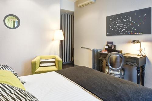 a hotel room with a bed and a desk and a chair at ZE Hotel in Paris