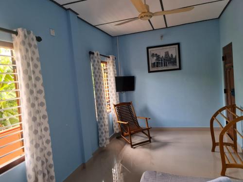 a living room with blue walls and a rocking chair at Nalluran illam - family room in Jaffna