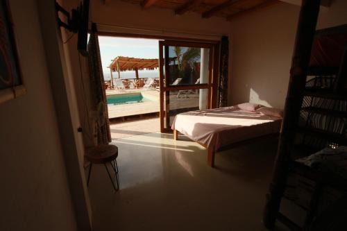 una camera con letto e vista sulla piscina di Casa Vistamar y Bungalows a Los Órganos