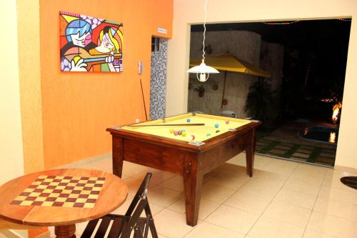a pool table in a living room with a table at Pousada Recanto do Sal in Salinópolis