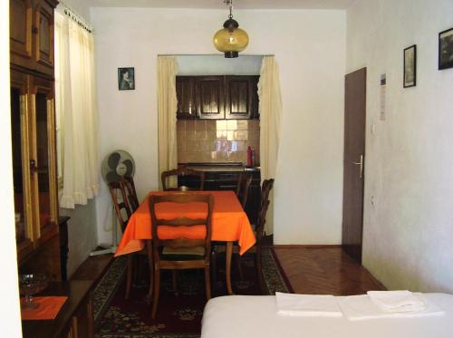 a kitchen with a table with an orange table cloth on it at Apartments by the sea Pisak, Omis - 1003 in Mimice