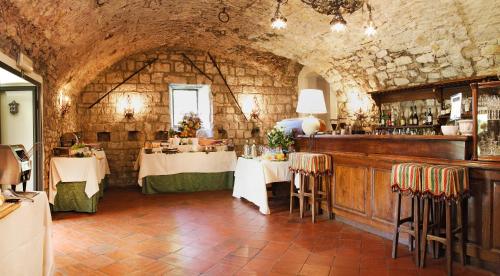 a restaurant with tables and chairs in a stone room at Castello di Spaltenna Exclusive Resort & Spa in Gaiole in Chianti