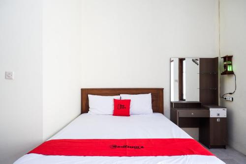 a bedroom with a red pillow on a bed at RedDoorz @ Umbul Ponggok Waterpark Klaten in Klaten
