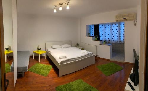 a bedroom with a bed and a room with green rugs at New Green Apartment Studio 1 in Bucharest
