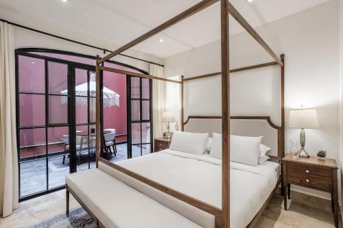 a bedroom with a four poster bed and a table at Luxury Apartments in Centro San Miguel de Allende with Rooftop & Jacuzzi in San Miguel de Allende