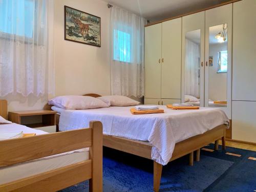 1 dormitorio con 2 camas y espejo en Apartments with a parking space Silo, Krk - 18729, en Šilo