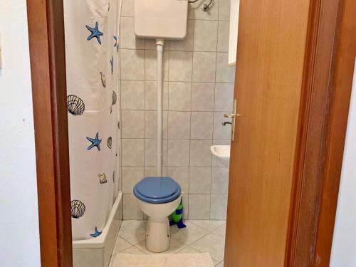 y baño con aseo azul y ducha. en Apartments with a parking space Silo, Krk - 18729, en Šilo