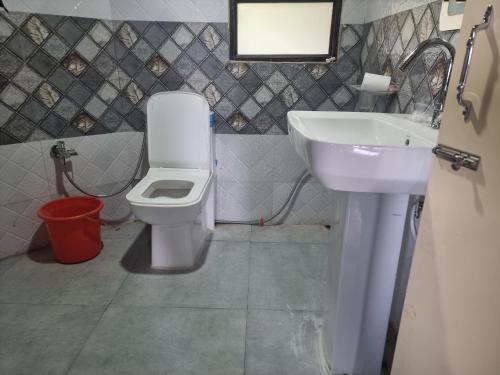 a bathroom with a white toilet and a sink at Kheychun homestay in Darjeeling