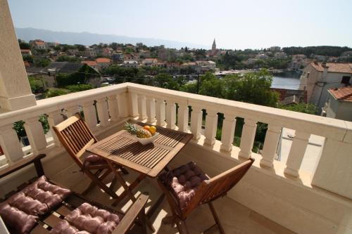 a table and chairs on a balcony with a view at Apartments by the sea Sumartin, Brac - 18749 in Sumartin