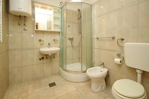 La salle de bains est pourvue d'une douche, de toilettes et d'un lavabo. dans l'établissement Apartments with a parking space Silo, Krk - 18751, à Šilo