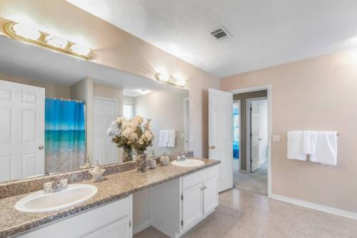 uma casa de banho com 2 lavatórios e um espelho grande em Seaside Sanctuary close to Navarre Beach! em Navarre
