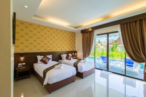 a hotel room with two beds and a balcony at The Casita Phuket (SHA+) in Ban Bo Sai Klang