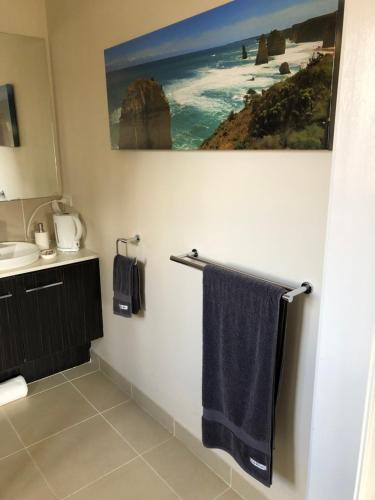 a bathroom with a blue towel hanging on a towel rack at 5 Star Room with own Bathroom - Singles, Couples, Families or Executives in Glen Waverley