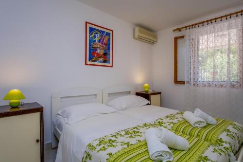 a bedroom with a white bed with towels on it at Apartments by the sea Nerezine, Losinj - 18734 in Nerezine