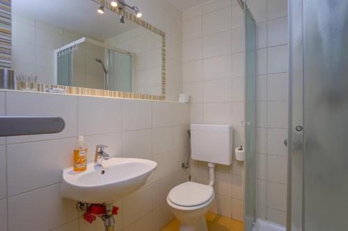 a bathroom with a sink and a toilet and a mirror at Apartments by the sea Nerezine, Losinj - 18734 in Nerezine