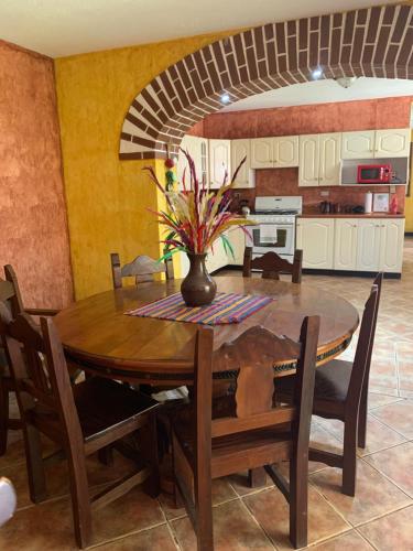 a dining room table with a vase on top of it at Casona del Conquistador in Antigua Guatemala