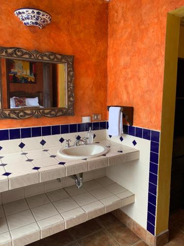 y baño con lavabo y espejo. en Casa El Conquistador, en Antigua Guatemala