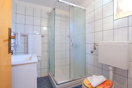 een badkamer met een douche, een toilet en een wastafel bij Apartments with a parking space Okrug Donji, Ciovo - 18796 in Okrug Gornji