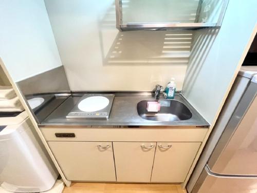 a small kitchen with a sink in a small refrigerator at Hamamoto Palace Taniyama - Vacation STAY 11251 in Kagoshima